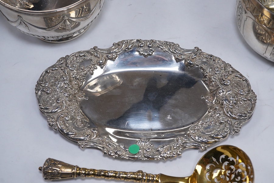 Two Victorian silver sugar bowls, a Victorian silver gilt sifter ladle and a repousse silver dish, 11.8oz. Condition - fair to good